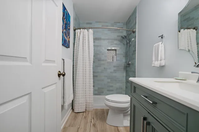 a bathroom with a sink a toilet and shower