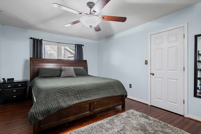 a bedroom with a bed and wooden floor