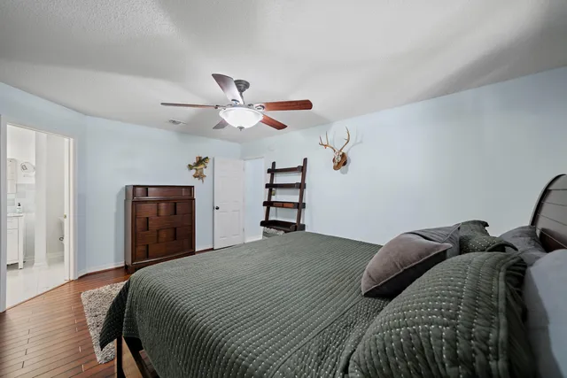 a bedroom with a bed and a ceiling fan