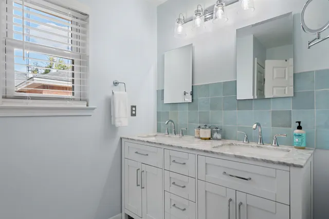 a kitchen with white cabinets and a window
