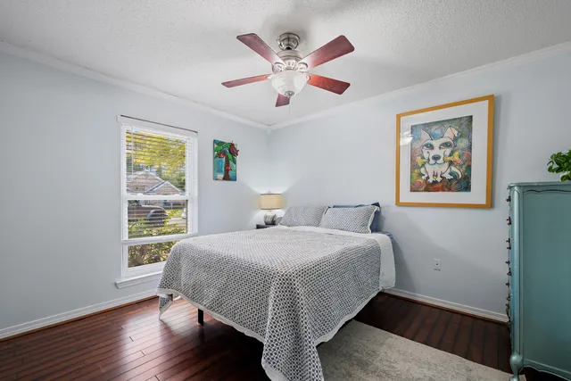 a bedroom with a large bed and two window