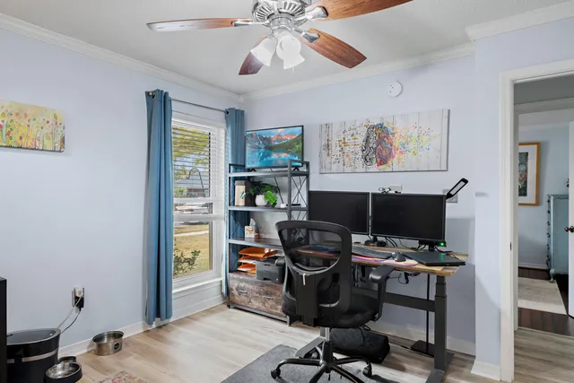 a view of a workspace with furniture and a window