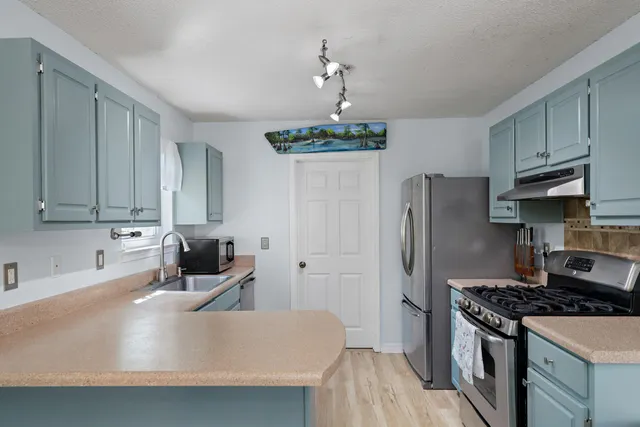 a kitchen with stainless steel appliances granite countertop a sink stove and refrigerator
