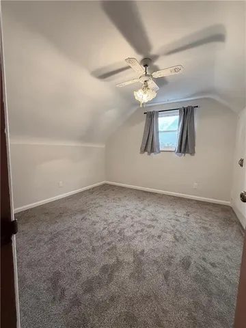 an empty room with fan and windows