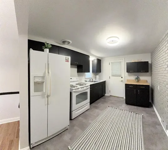 a kitchen with stainless steel appliances a refrigerator sink and white cabinets