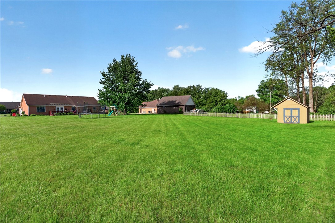 4996 Shannon Avenue Springfield, OH 45504 - Photo 58 of 61 Expansive green lawn perfect for outdoor activities with a charming shed and a white picket fence.
