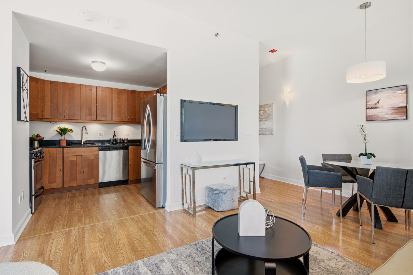 340 West Superior Street, Unit 1009 Chicago, IL 60654 - Photo 7 of 24 a living room with stainless steel appliances furniture a dining table and a flat screen tv