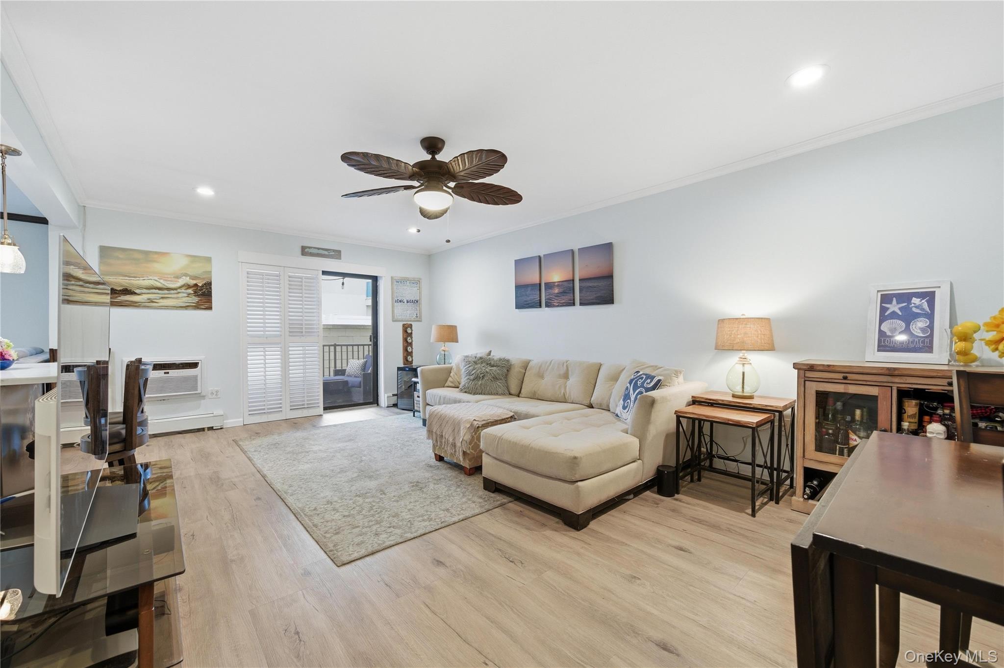 Living area featuring ornamental molding, light wood-style flooring, ceiling fan, recessed lighting, and baseboard heating