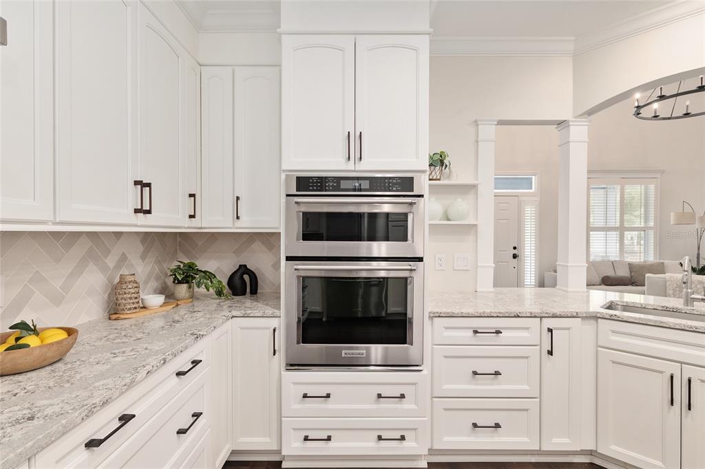 303 Southwest 129 Terrace Newberry, FL 32669 - Photo 20 of 75 a kitchen with granite countertop white cabinets and stainless steel appliances