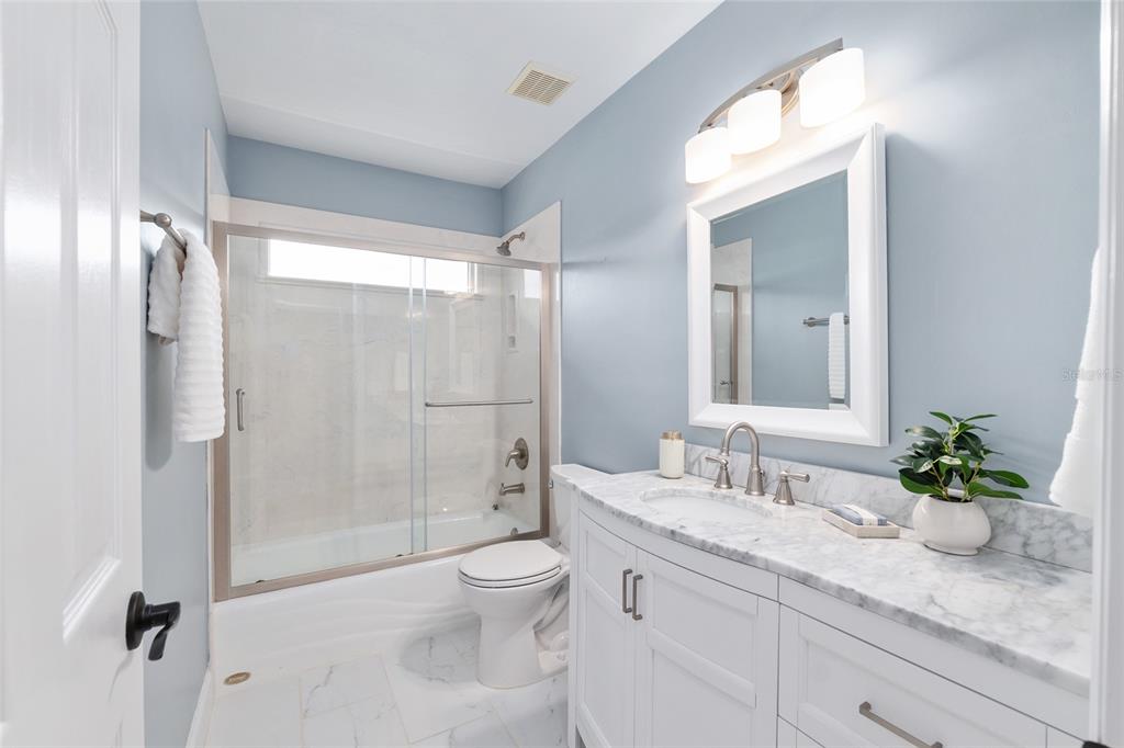 303 Southwest 129 Terrace Newberry, FL 32669 - Photo 42 of 75 a bathroom with a granite countertop sink a toilet a large mirror and shower
