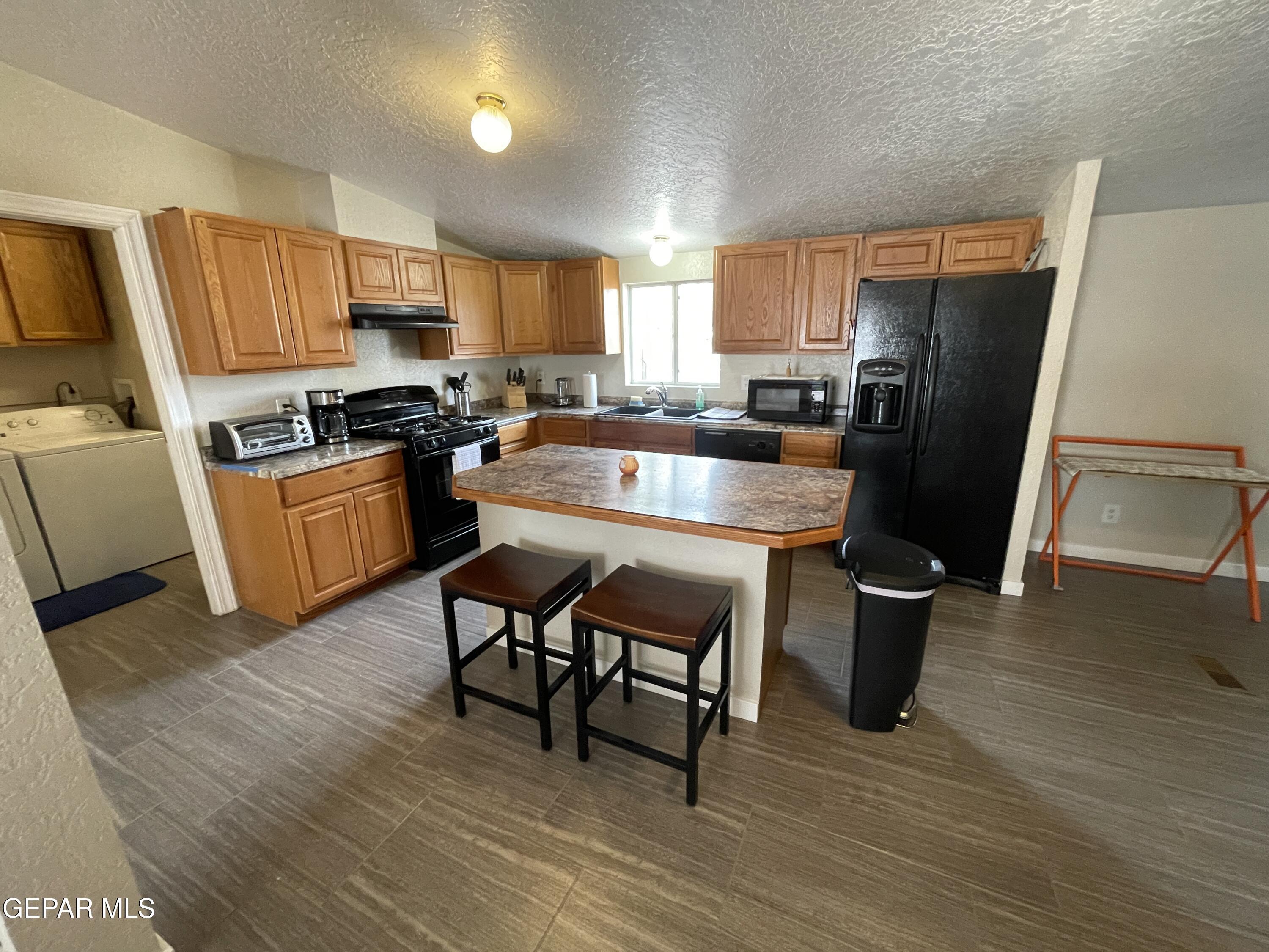 2901 Cook Street Truth Or Consequences, NM 87901 - Photo 6 of 28 a kitchen with stainless steel appliances granite countertop a refrigerator a stove top oven a sink and dishwasher