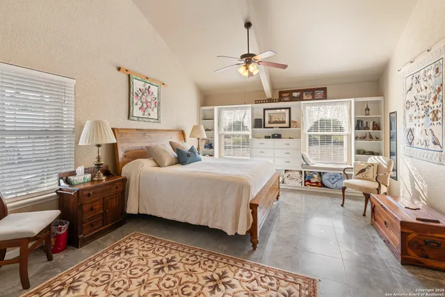 a spacious bedroom with a bed and a chandelier