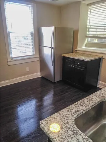 a kitchen with granite countertop a stove a refrigerator and a microwave