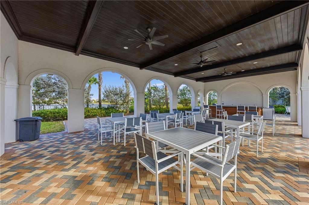 5172 Bergamo Way Ave Maria, FL 34142 - Photo 28 of 33 a view of a patio with dining table and chairs with plants
