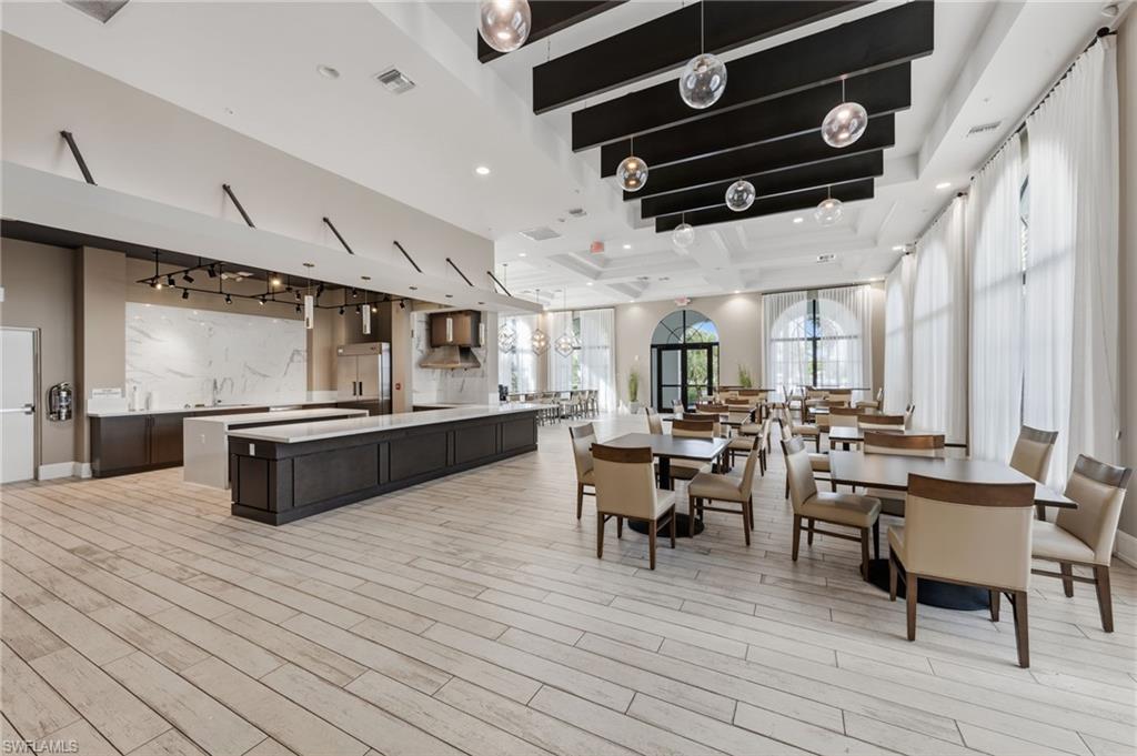 5172 Bergamo Way Ave Maria, FL 34142 - Photo 29 of 33 a living room with stainless steel appliances kitchen island granite countertop furniture wooden floor and windows