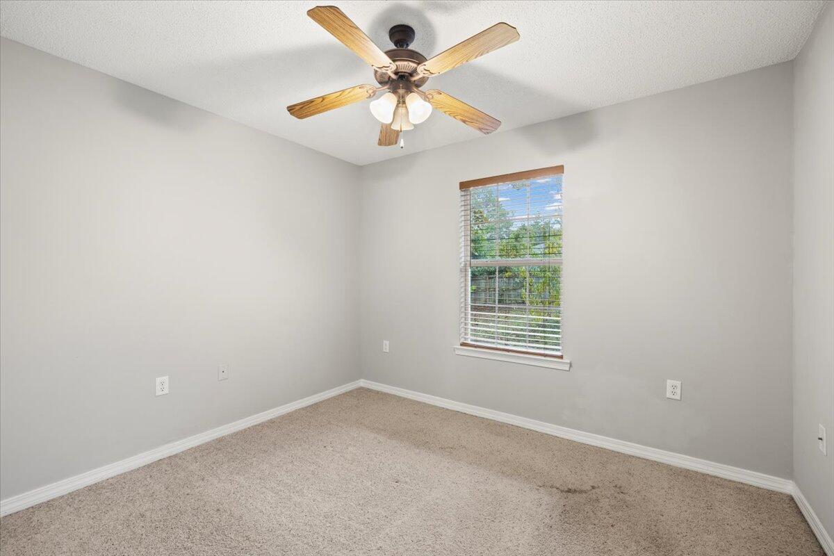 3140 Skyline Drive Crestview, FL 32539 - Photo 11 of 29 an empty room with windows and fan