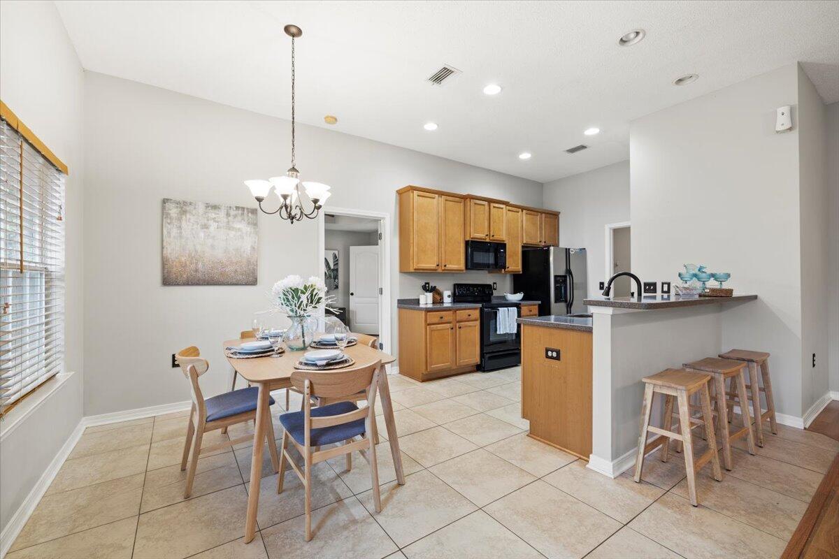 3140 Skyline Drive Crestview, FL 32539 - Photo 21 of 29 a dining room filled chandelier and kitchen view
