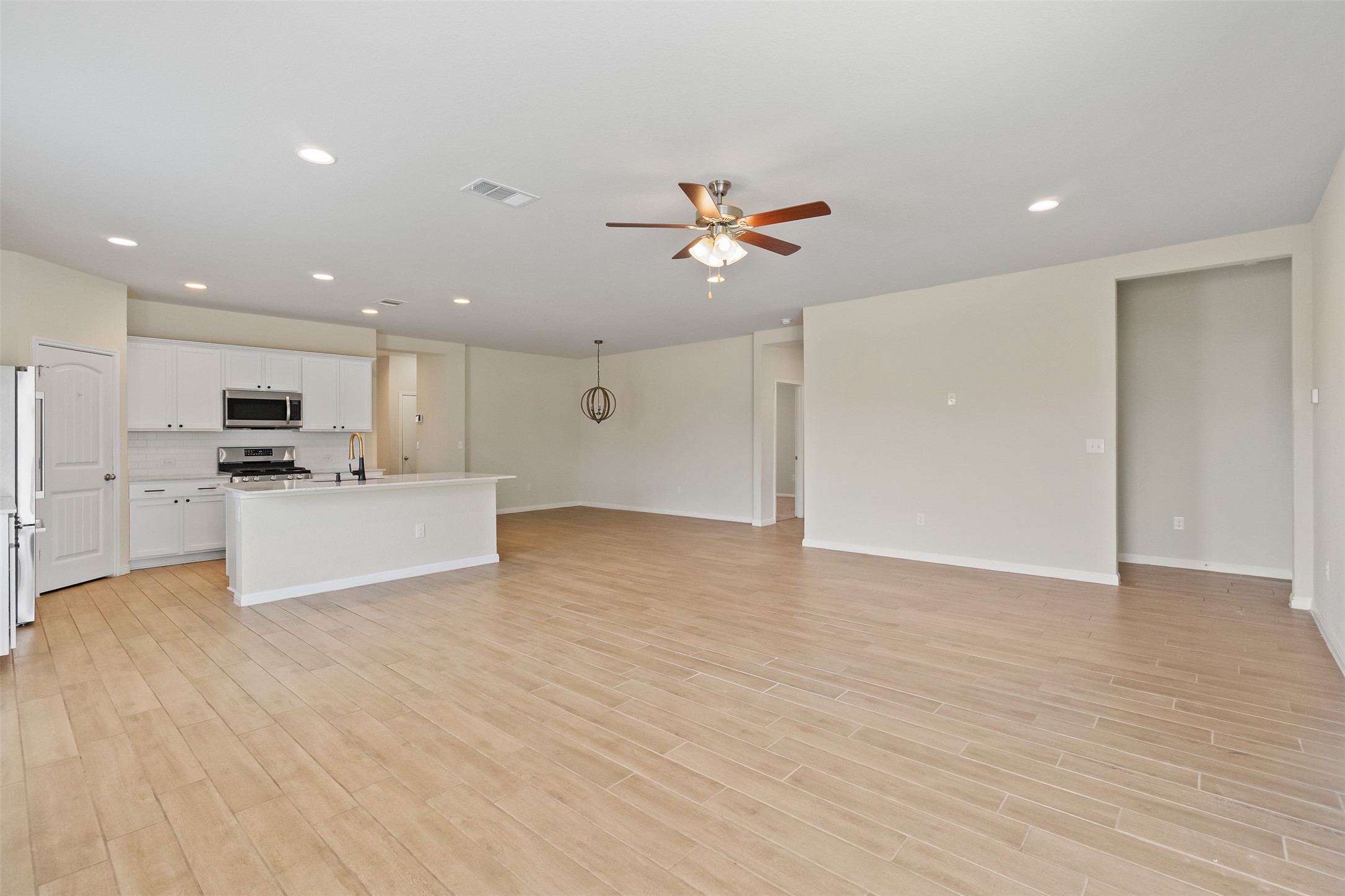 4125 Buffalo Ford Road Georgetown, TX 78628 - Photo 12 of 28 Unfurnished living room with a ceiling fan, light wood finished floors, and recessed lighting
