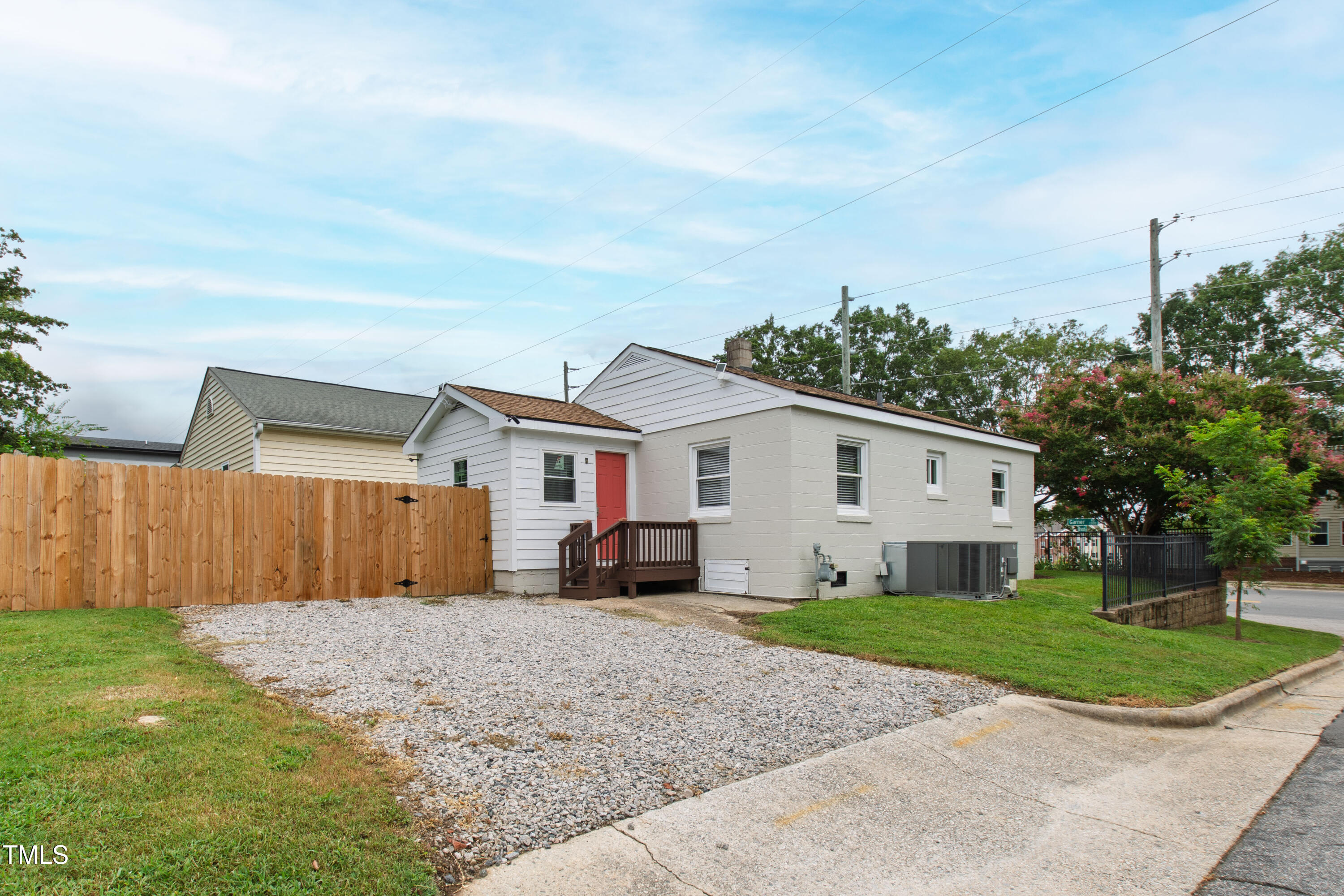1220 Garner Road Raleigh, NC 27610 - Photo 22 of 26 a view of a white house in front of a big yard with plants and large tree