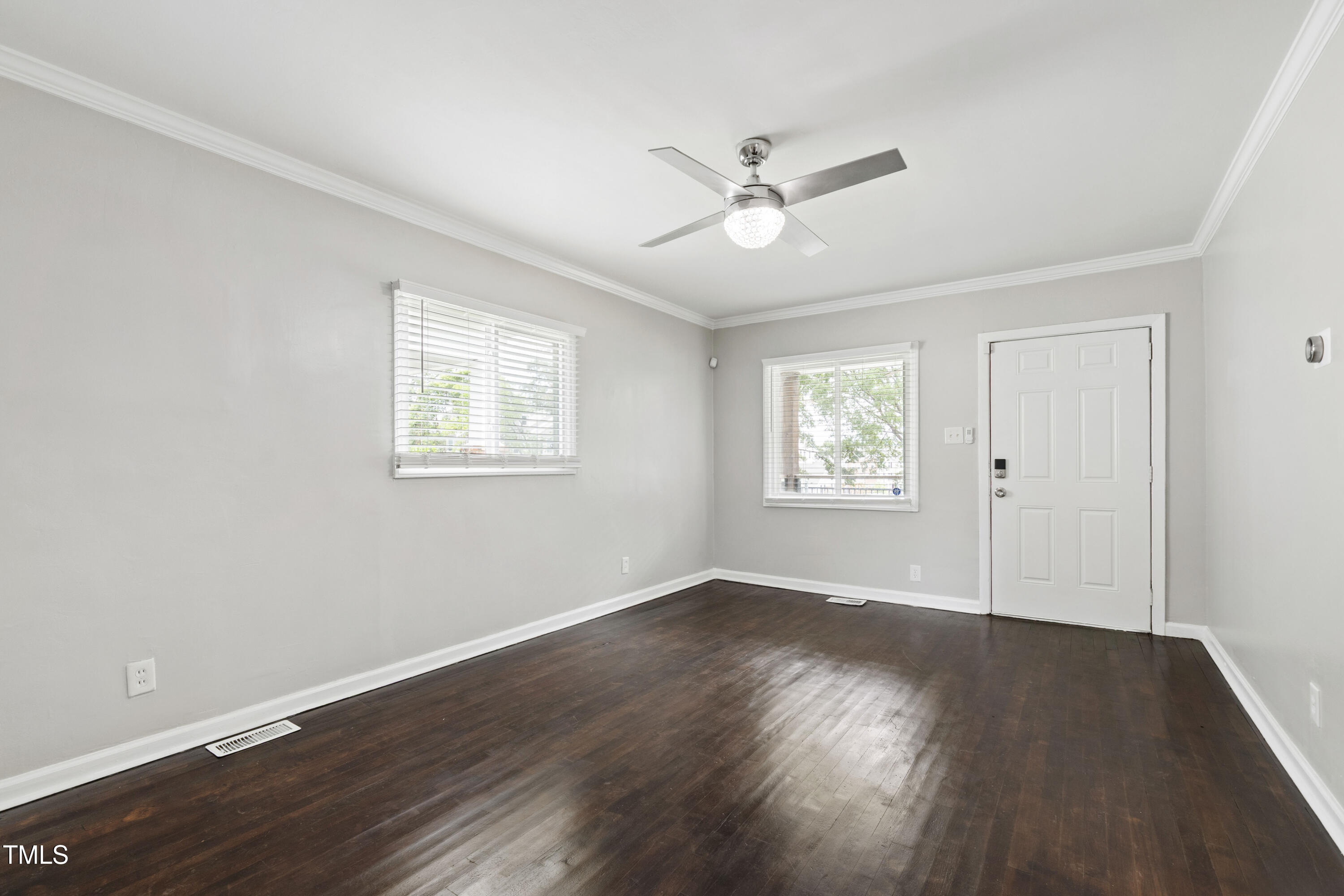 1220 Garner Road Raleigh, NC 27610 - Photo 3 of 26 a view of an empty room with wooden floor and a window
