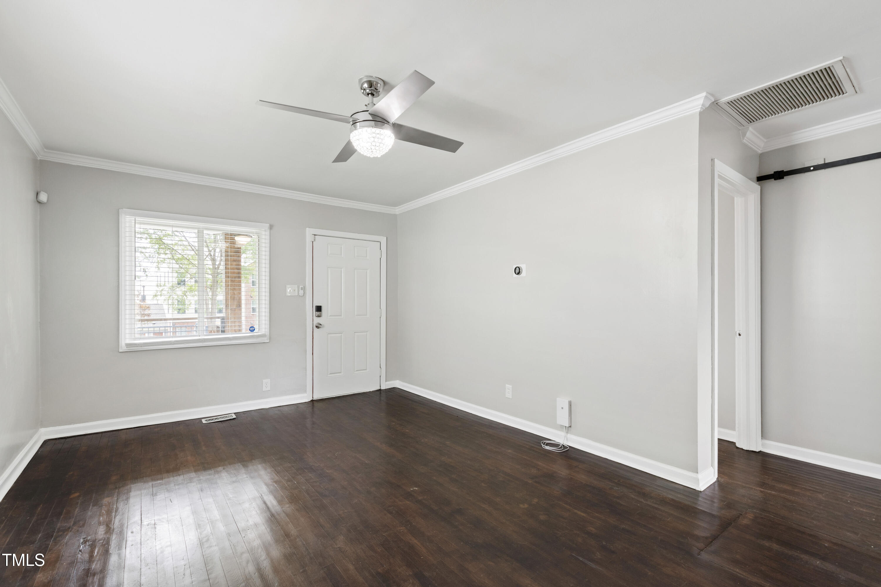 1220 Garner Road Raleigh, NC 27610 - Photo 4 of 26 a view of an empty room with wooden floor and a window