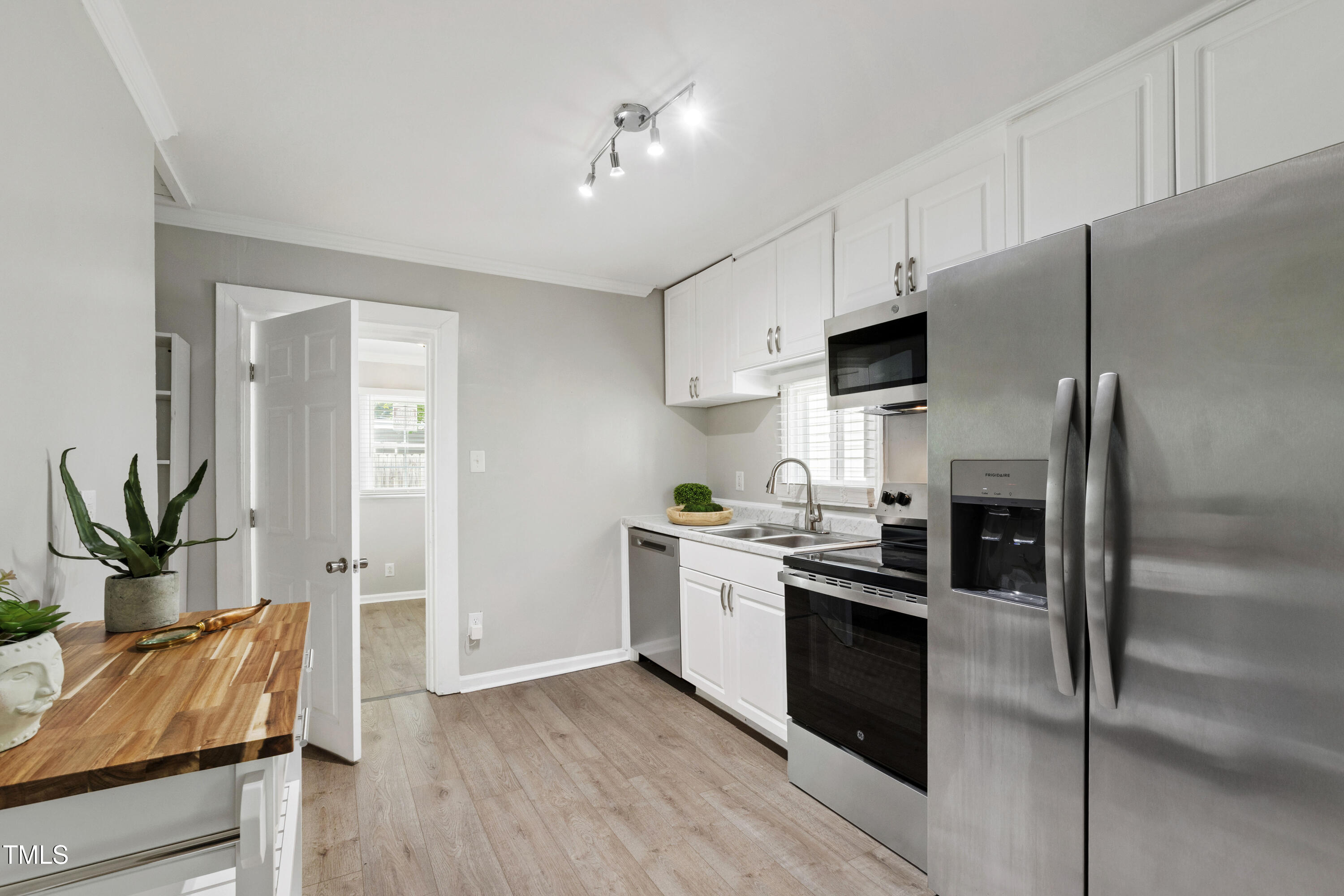 1220 Garner Road Raleigh, NC 27610 - Photo 8 of 26 a kitchen with stainless steel appliances a stove a sink and a refrigerator