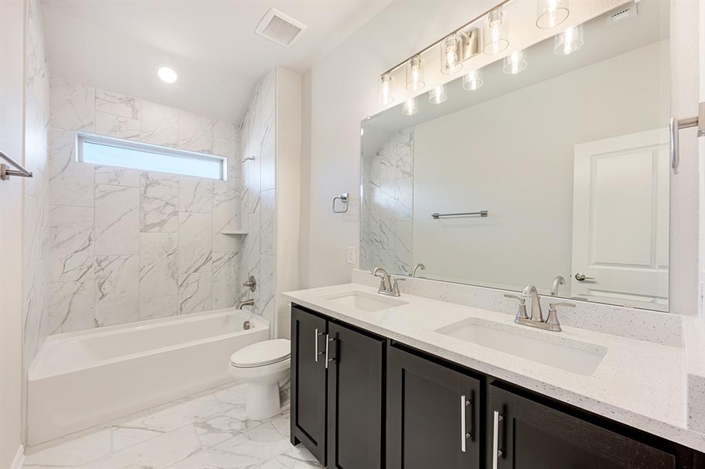 5622 Rowlan Row Midlothian, TX 76065 - Photo 35 of 39 a bathroom with a granite countertop sink a toilet a bathtub and shower
