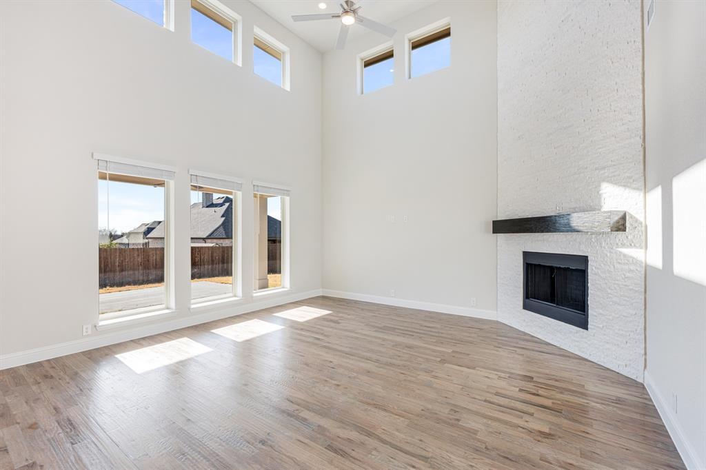 5622 Rowlan Row Midlothian, TX 76065 - Photo 8 of 35 a view of an empty room with wooden floor and a fireplace
