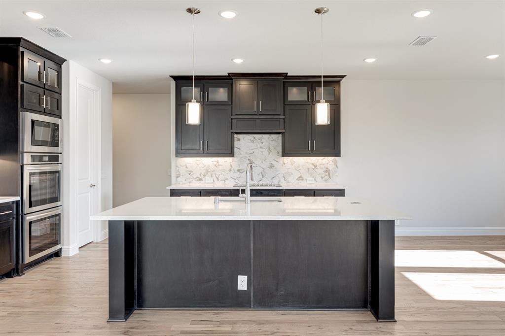 5622 Rowlan Row Midlothian, TX 76065 - Photo 10 of 35 a kitchen with kitchen island a counter top and stainless steel appliances