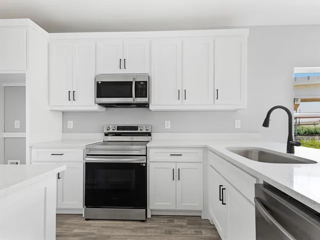 a kitchen with white cabinets and stainless steel appliances