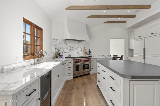 a kitchen with granite countertop a sink stove and cabinets