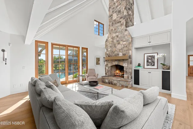 a living room with furniture large window and fireplace