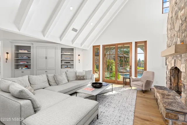 a living room with furniture large window and a fireplace