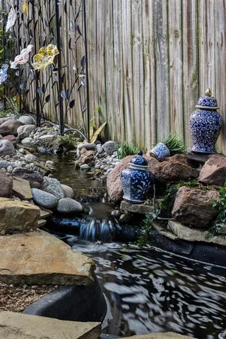 a view of a backyard with chair and potted plants