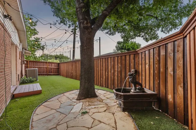 a view of small garden with wooden fence