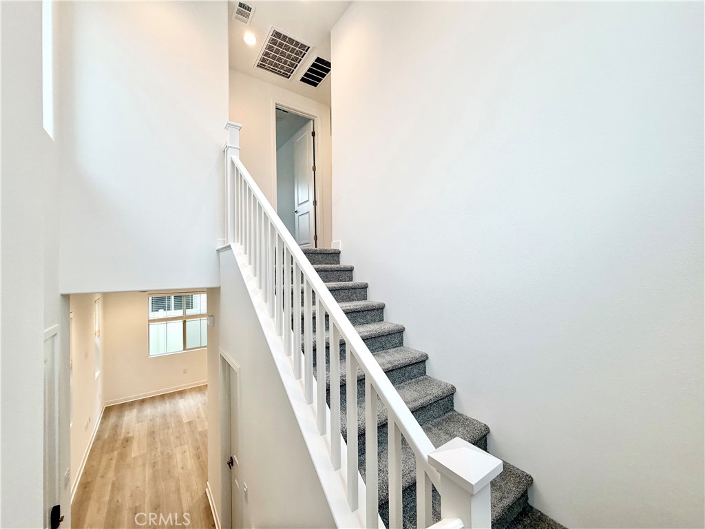 26893 Rubicon Road Menifee, CA 92586 - Photo 14 of 32 a view of staircase with lots of frames on wall and a window