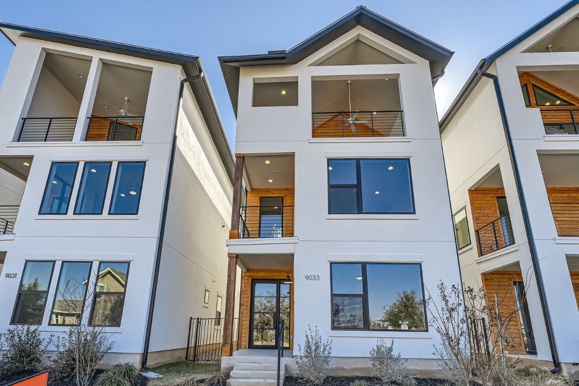 a view of a brick house with many windows and a door