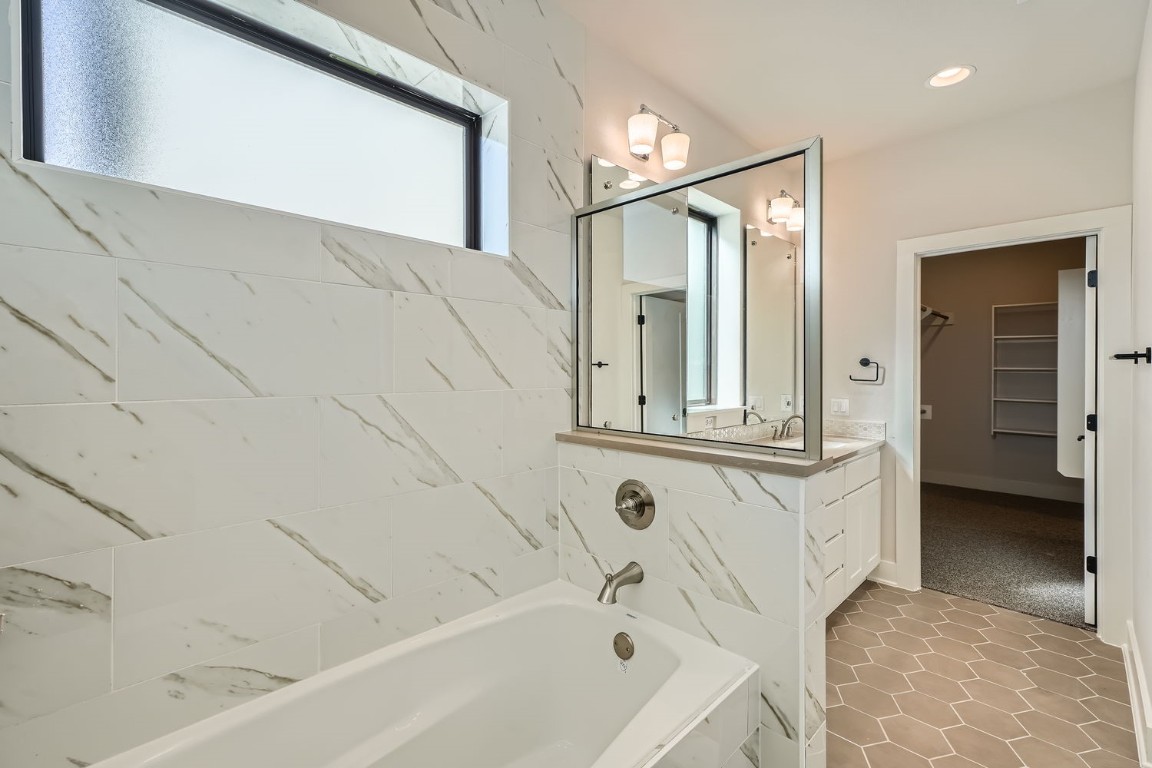 9033 Cattle Baron Path Austin, TX 78747 - Photo 18 of 28 a bathroom with a bathtub and a shower