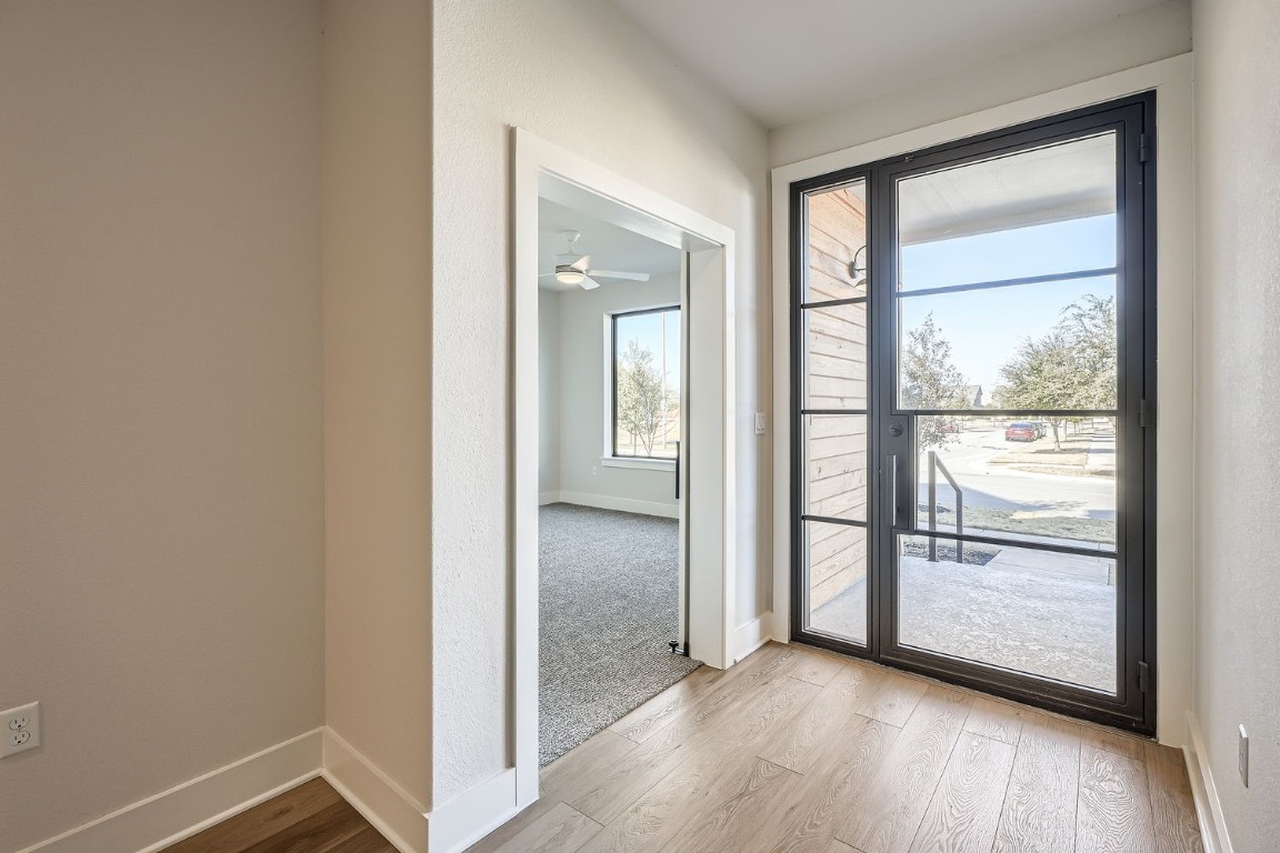 9033 Cattle Baron Path Austin, TX 78747 - Photo 3 of 28 an empty room with wooden floor and a window