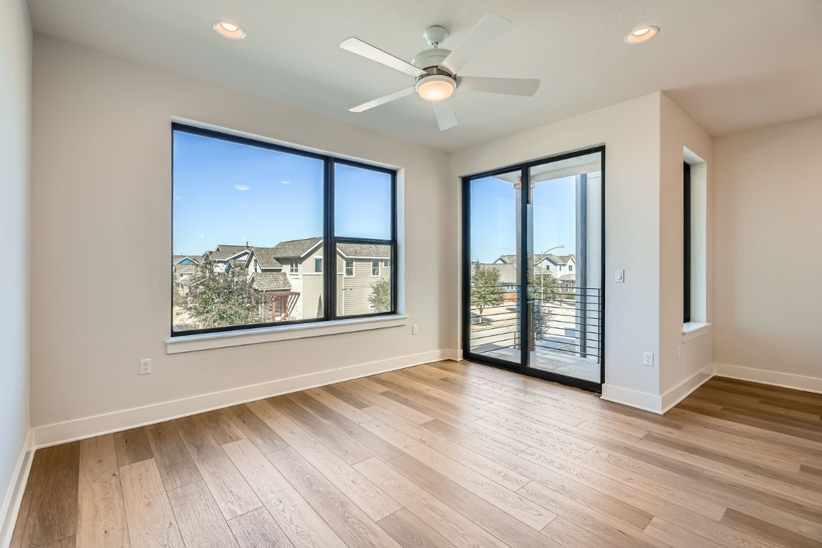 9033 Cattle Baron Path Austin, TX 78747 - Photo 4 of 28 a view of an empty room with window and wooden floor