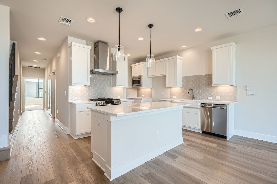9033 Cattle Baron Path Austin, TX 78747 - Photo 6 of 28 a kitchen with stainless steel appliances granite countertop a sink a stove and a wooden floors