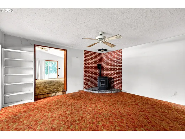 a view of an empty room with a fireplace and a window