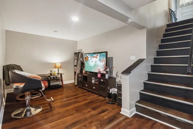 a view of a livingroom with wooden floor and furniture