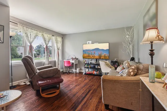 a living room with furniture a wooden floor and a large window