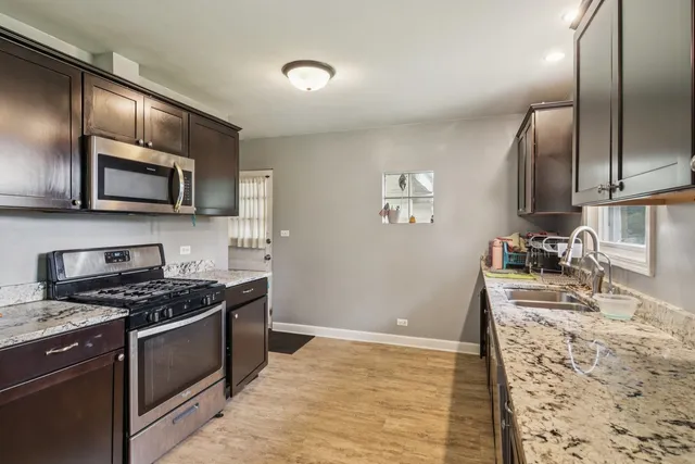 a kitchen with granite countertop stainless steel appliances and wooden cabinets