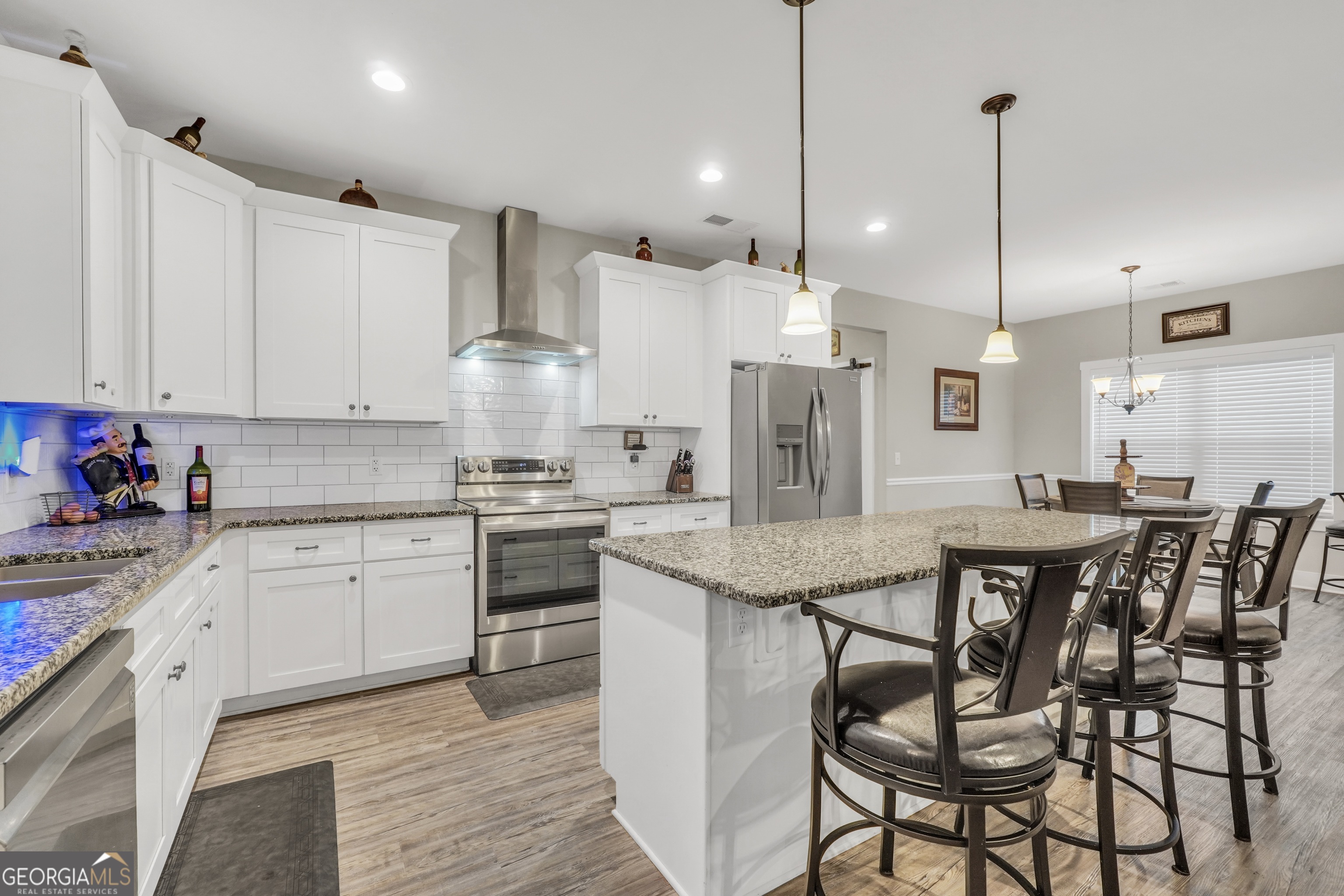 2985 Teamon Road Griffin, GA 30223 - Photo 14 of 50 a kitchen with stainless steel appliances kitchen island granite countertop a table chairs sink and cabinets