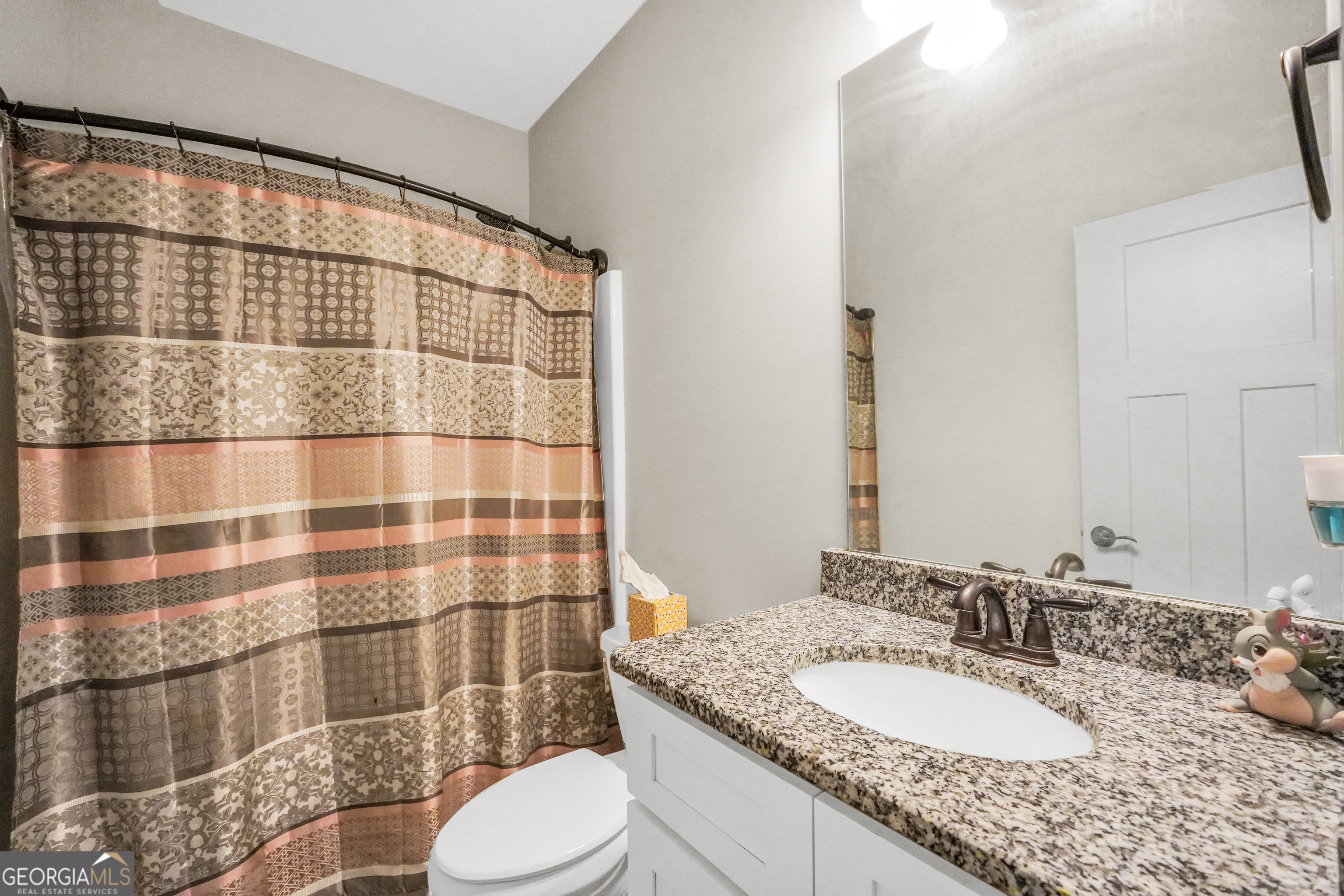 2985 Teamon Road Griffin, GA 30223 - Photo 30 of 50 a bathroom with a granite countertop sink toilet a mirror and shower