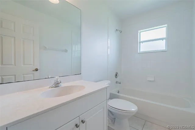a view of an empty room with wooden floor and a large window