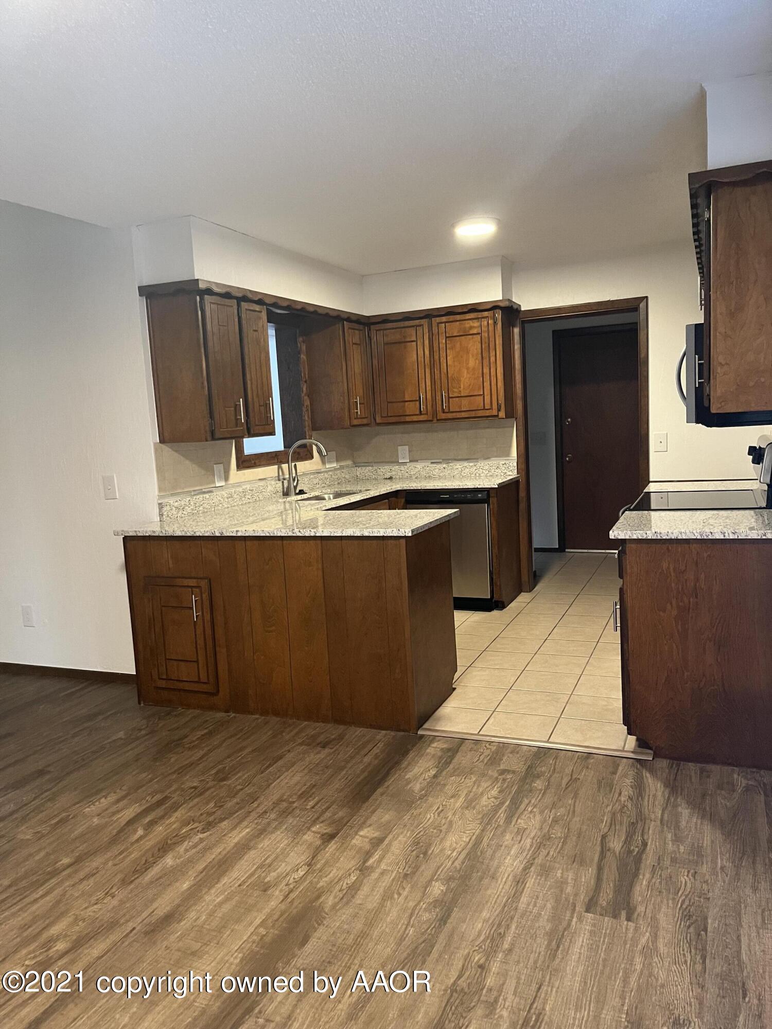 4308 Ridgecrest Circle Amarillo, TX 79109 - Photo 6 of 12 a large kitchen with kitchen island granite countertop a sink and a stove top oven