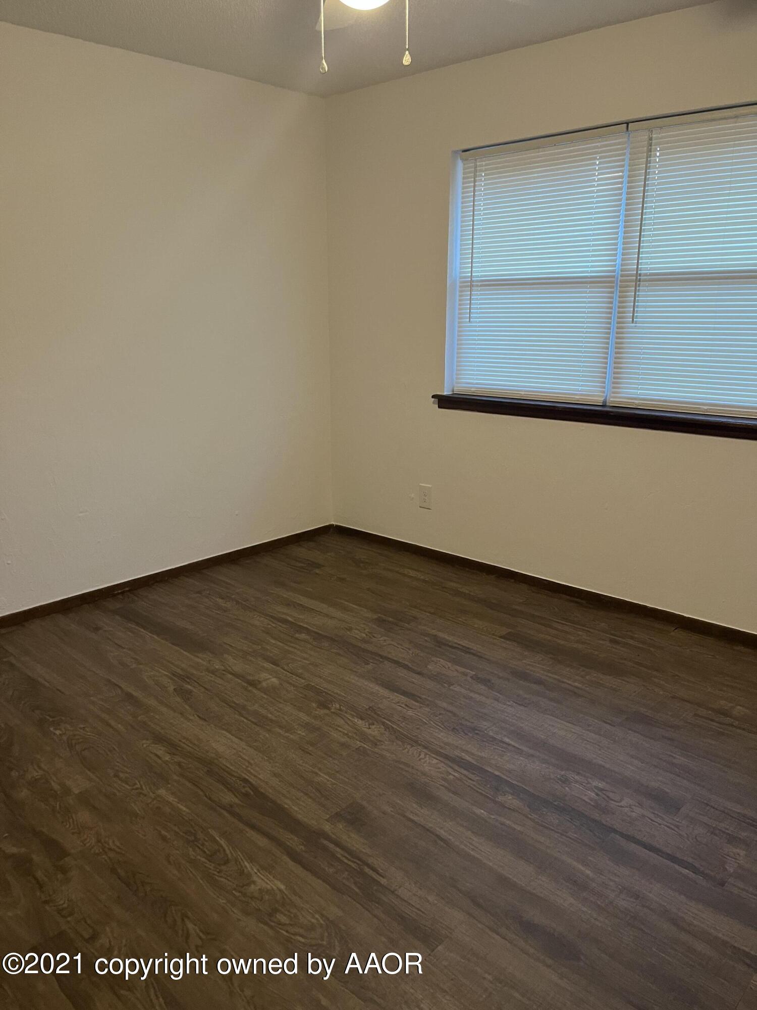 4308 Ridgecrest Circle Amarillo, TX 79109 - Photo 8 of 12 an empty room with wooden floor and windows